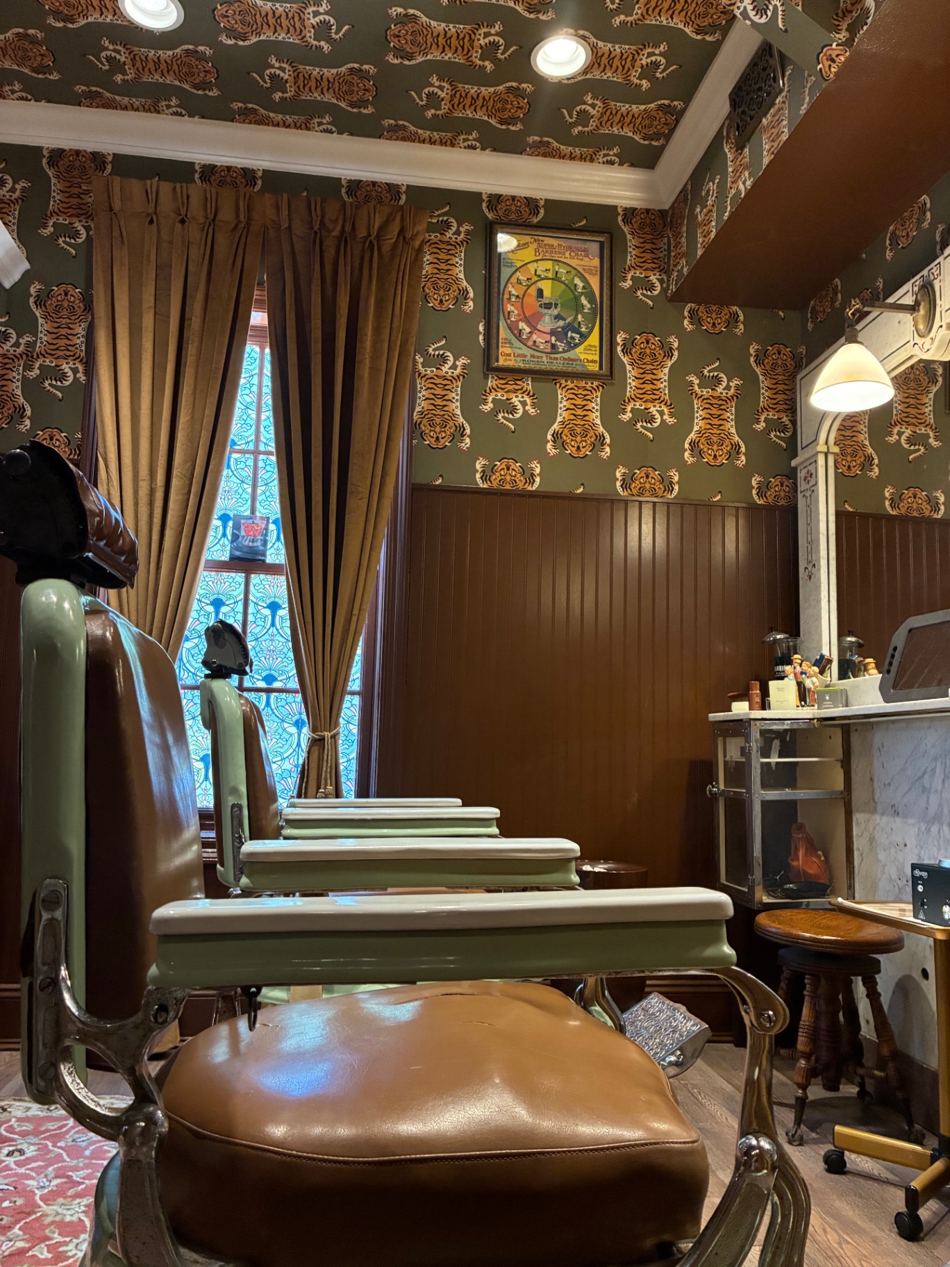 Vintage barber chairs beneath tiger-print wallpaper inside LaSala's barbershop